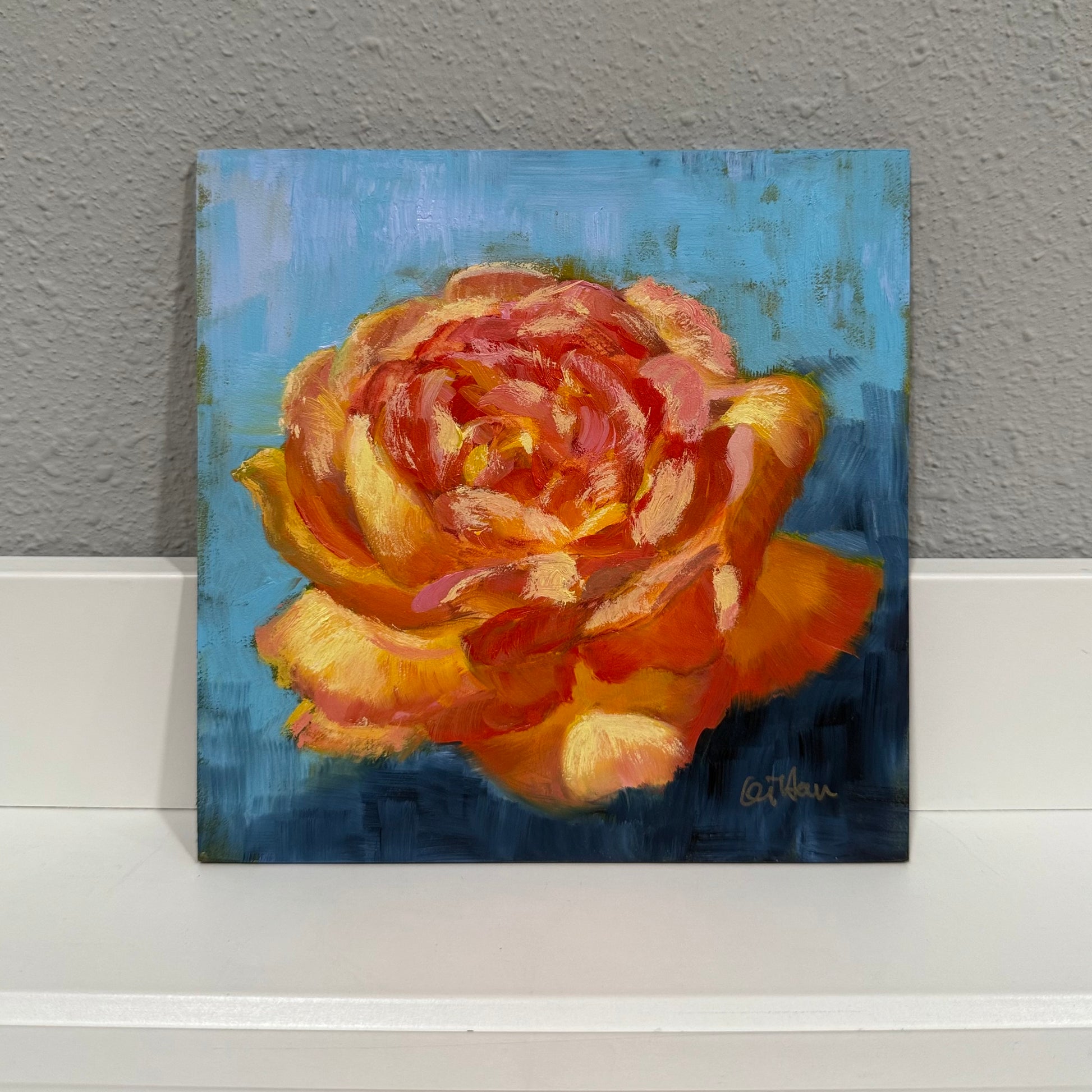 Painting of a red and yellow rose on a blue background