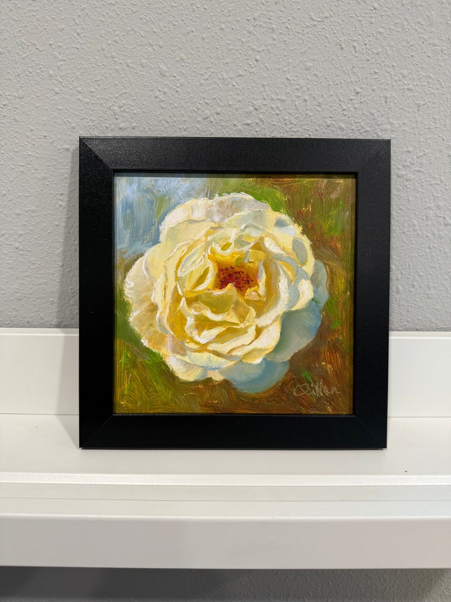 Framed painting of a white flower on a gray wall