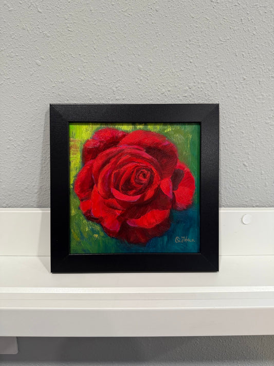 Framed painting of a red rose on a gray wall