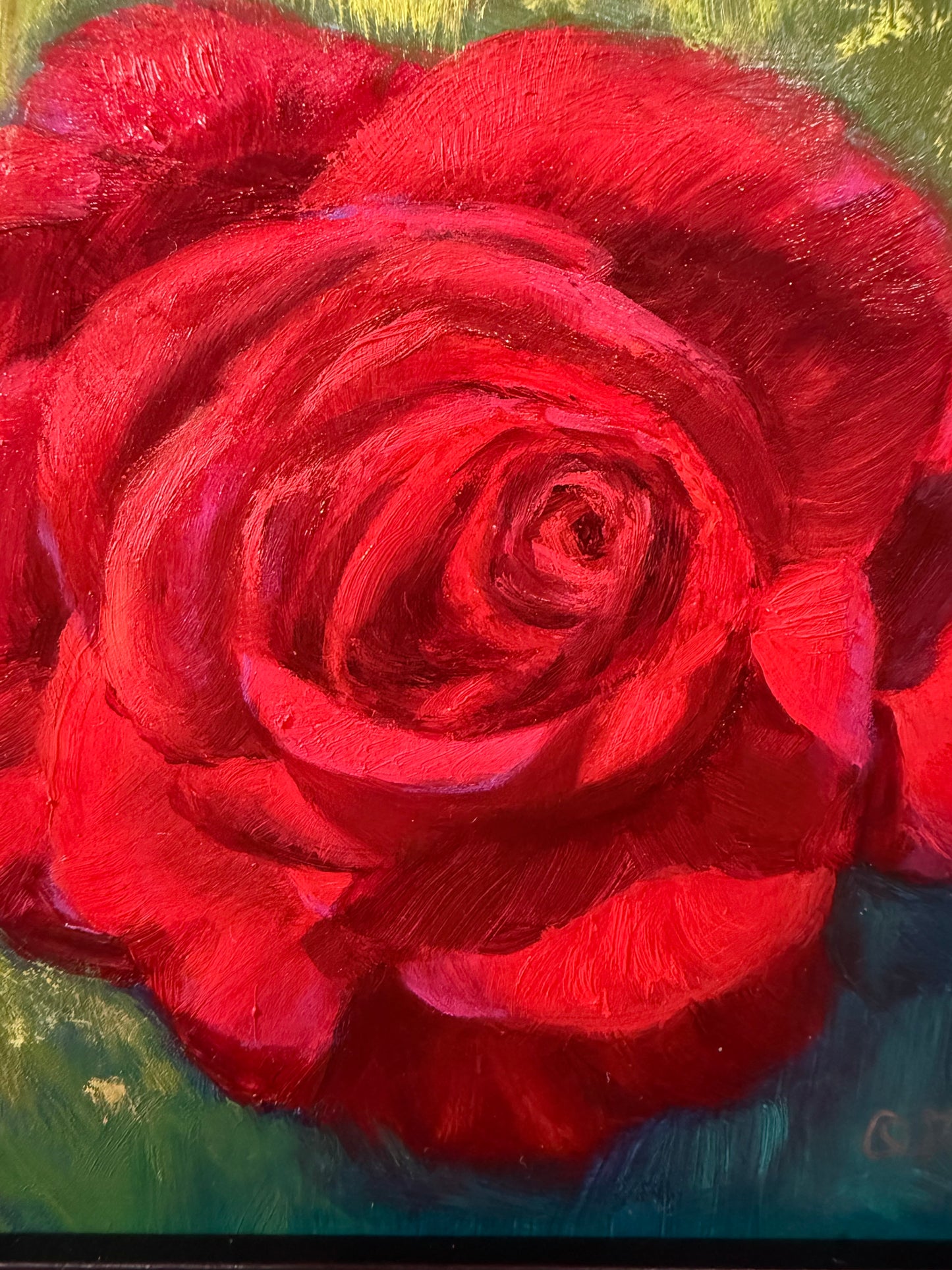 Close-up of a red rose with a textured surface on a multicolored background