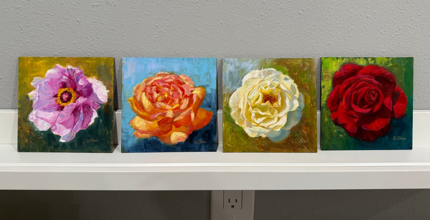 Four square paintings of flowers on a gray wall.